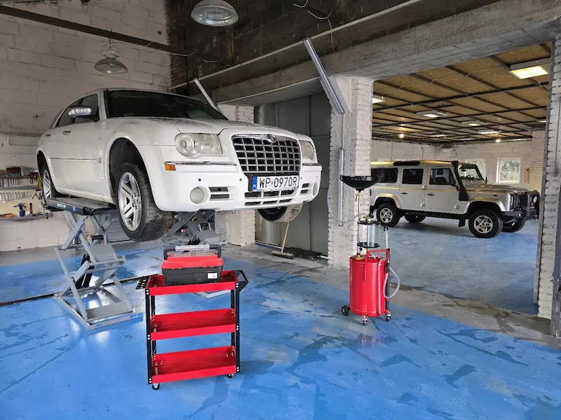 Samochód na podnośniku i nowoczesne wyposażenie warsztatu